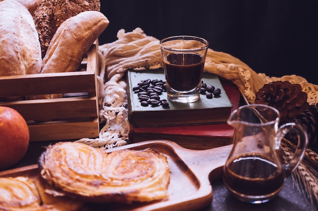 Baked breads, apples and coffee on a table.