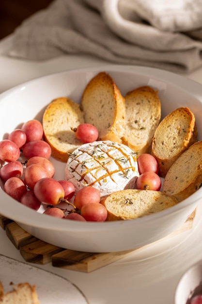 Baked brie cheese with bread and grapes