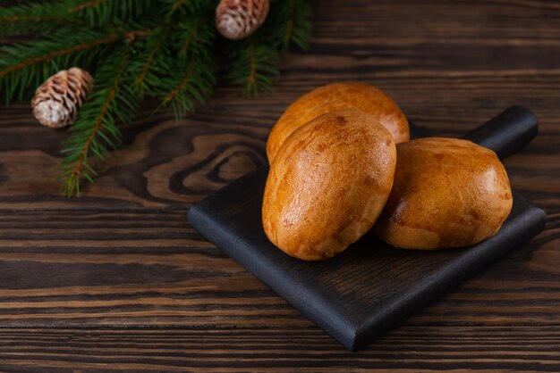 Baked buns on a wooden board.