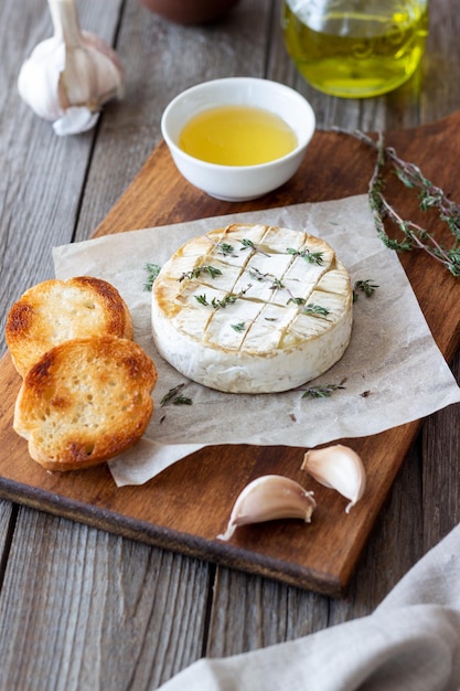 Baked Camembert cheese with garlic thyme and toasted bread French cuisine