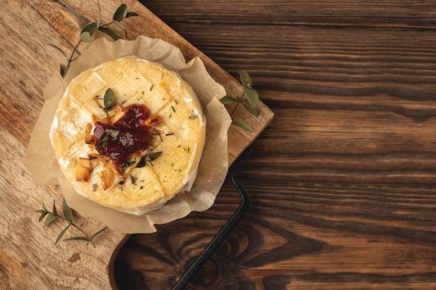 Baked camembert cheese, wooden background, copy space