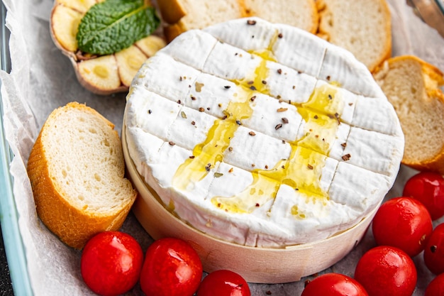 baked cheese Brie or Camembert with tomato, garlic and herbs healthy meal food snack on the table