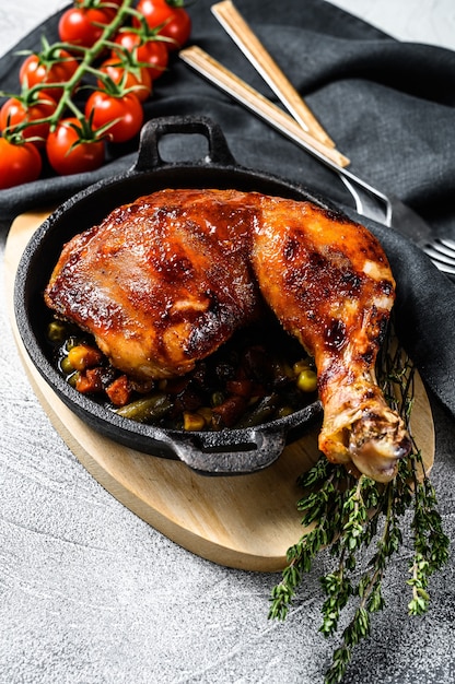 Baked chicken leg with seasonings in a frying pan