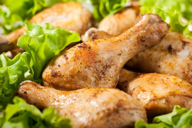 Baked chicken legs on plate, close up