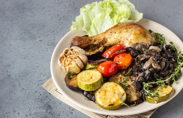 Baked chicken legs with vegetables and mushrooms with salad and thyme.