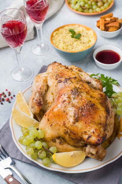 Baked chicken, mashed potatoes and wine glasses for dinner on the festive table.