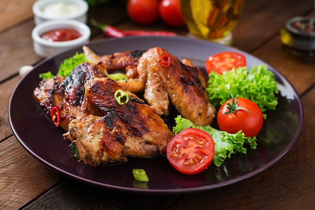 Baked chicken wings in pan on wooden table.