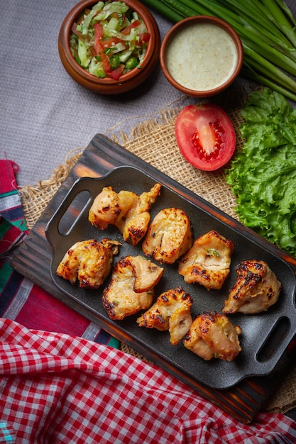 Baked chicken wings served with different sauces and lemon Black background