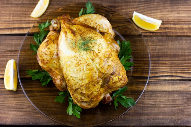 Baked chicken on wooden table. Festive lunch for the holidays. Cooked chicken at home