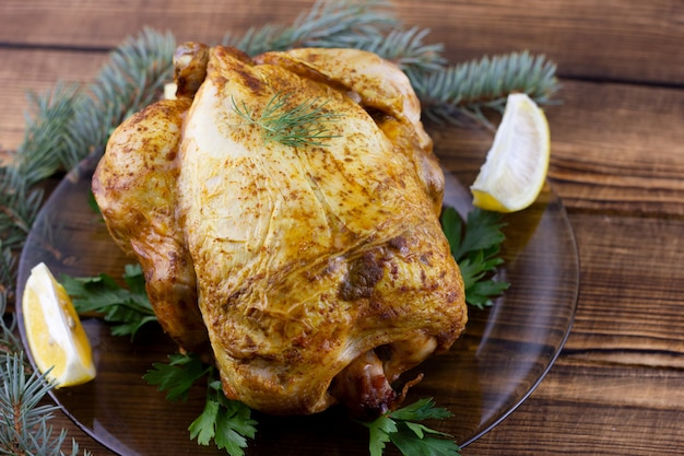 Baked chicken on wooden table. Festive lunch for the holidays. Cooked chicken at home