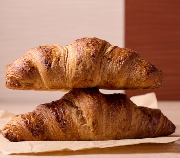 Baked crispy croissant on a wooden board breakfast