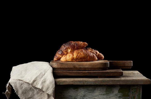 Baked croissants on brown kitchen board