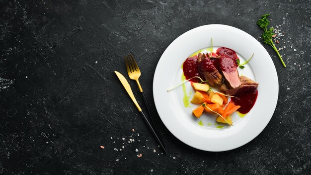 Baked duck breast with celery root and vegetables on a white plate Top view Rustic style