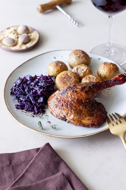 Baked duck leg with potatoes and red cabbage