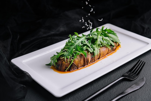 Baked eggplant with arugula and grated parmesan cheese