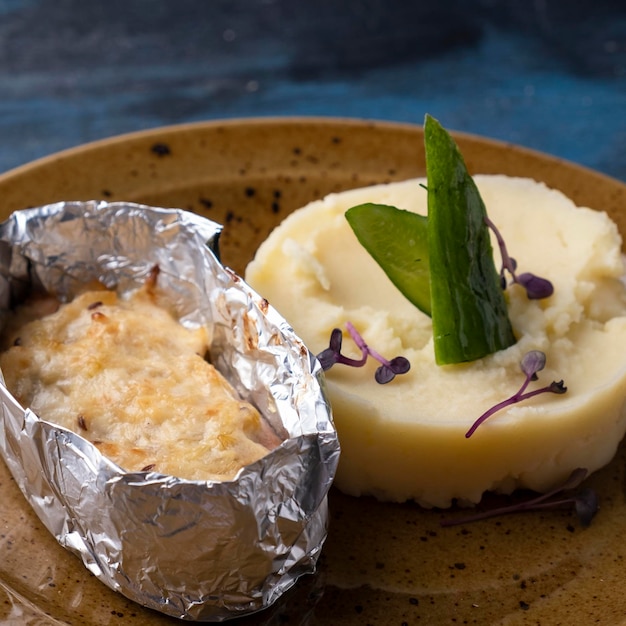 Baked fish under cheese with mushed potatoes