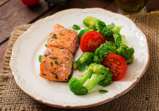 Photo baked fish salmon garnished with broccoli and tomato. dietary menu. fish menu. seafood - salmon.