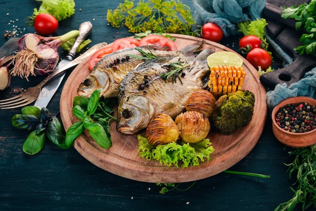 Baked fish with spices and vegetables Carp On a wooden background Top view Copy space