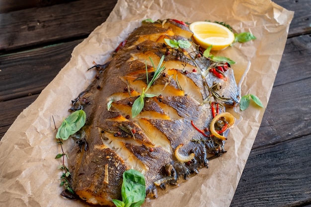 Baked flounder fish whole with seasonings, lemon and Basil on parchment