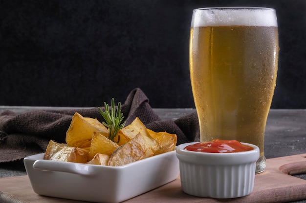 Baked fried potatoes with rosemary, coarse salt, olive oil and spice paprika in iron skillet and a pint of beer.