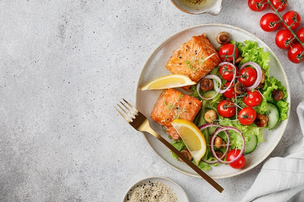 Baked Fried Salmon with fresh vegetables salad tomatoes cherry onion Concept keto diet healthy food