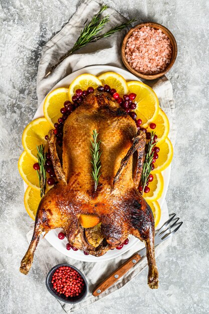 Baked goose stuffed with oranges and rosmarina. Festive table. Gray background. Top view