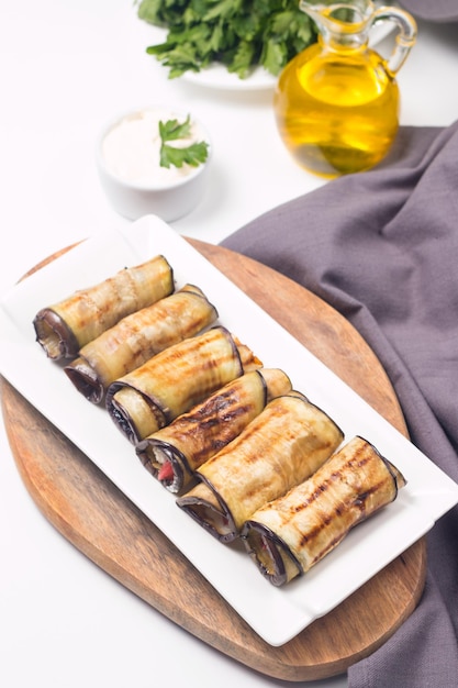 Baked grilled eggplant rolls with cottage cheese, tomatoes and sour cream. Georgian cuisine.