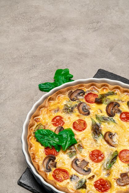 Baked homemade quiche pie in ceramic baking form