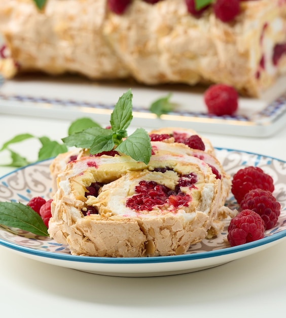 Baked meringue roll with cream and fresh red raspberry white background