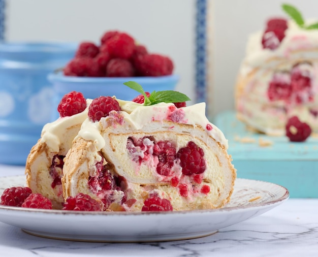 Baked meringue roll with cream and fresh red raspberry white backgroundx9