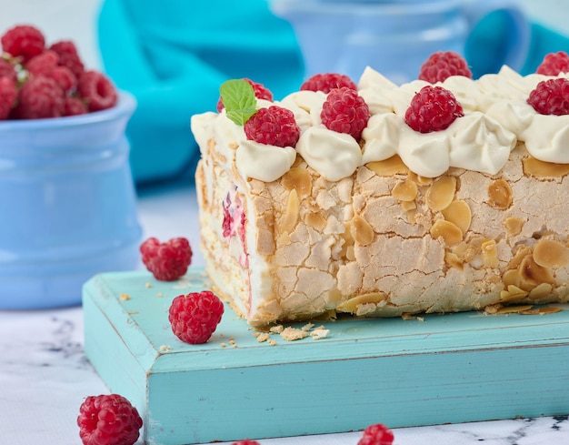 Baked meringue roll with cream and fresh red raspberry white backgroundx9