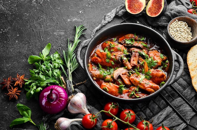 Baked mushrooms with chicken fillet in tomato sauce In a black stone plate Top view