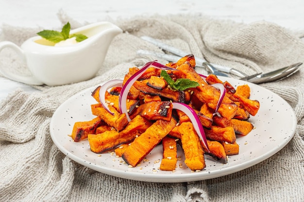 Baked organic batata fries with spices and sauce Sweet vegetable served portion and cutlery