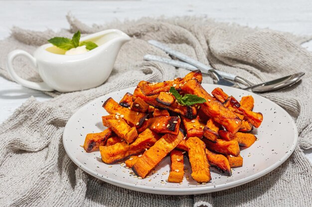 Baked organic batata fries with spices and sauce Sweet vegetable served portion and cutlery