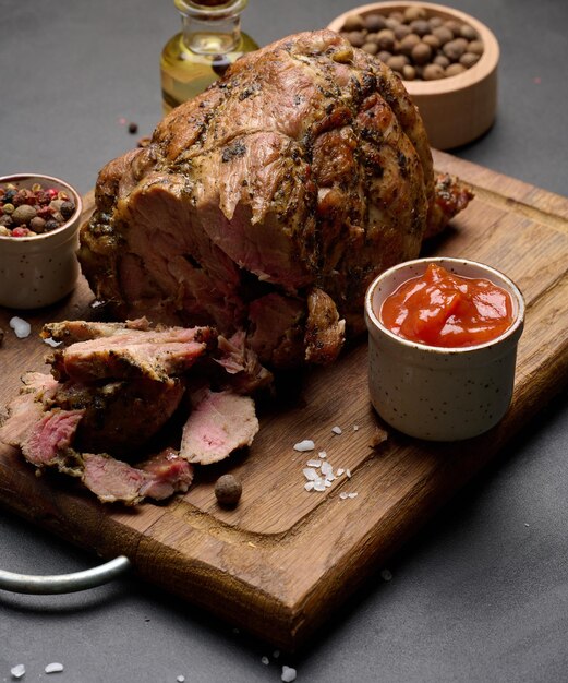 Baked pork collar with spices on a wooden board delicious and juicy meat