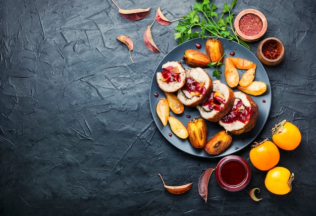 Baked pork roll with autumn persimmon.Meat stuffed with fruits.