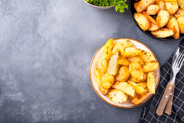 Baked potato segments with spices on a plate Top view copy space