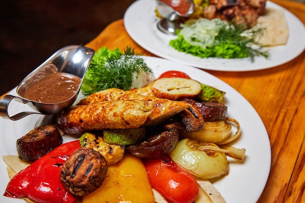 Baked potatoes and grilled vegetables with kebabs and sausages