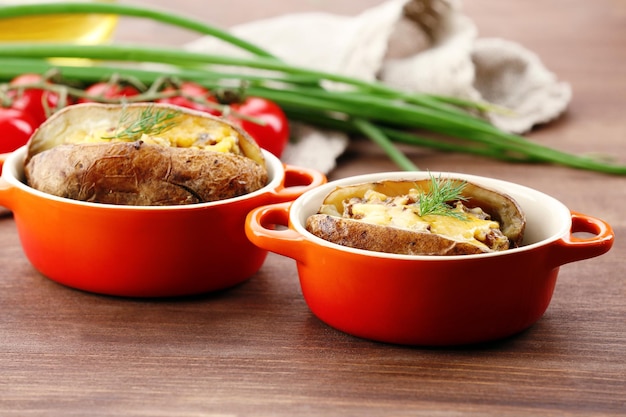 Baked potatoes with cheese and mushrooms on table close up