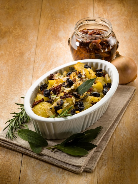 Baked potatoes with dried tomatoes and black olives