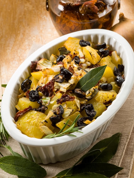 Baked potatoes with dried tomatoes and black olives