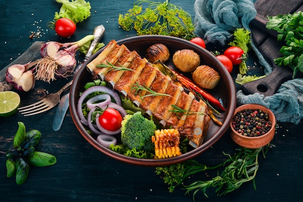 Baked ribs with vegetables Meat On a wooden background Top view Copy space