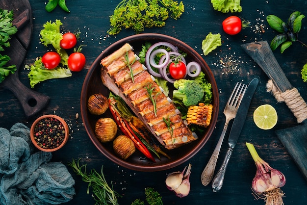 Baked ribs with vegetables Meat On a wooden background Top view Copy space