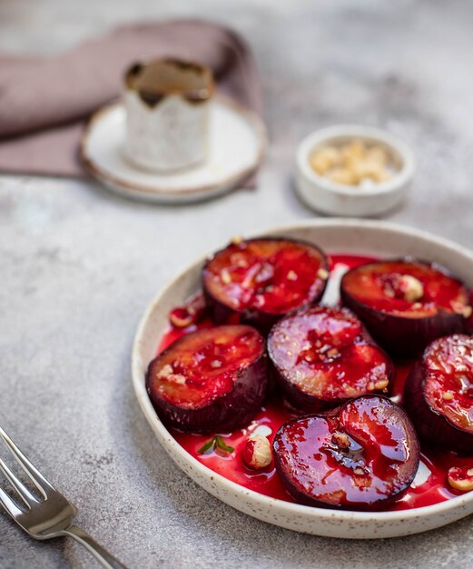 Baked ripe plums with honey, cinnamon and nuts