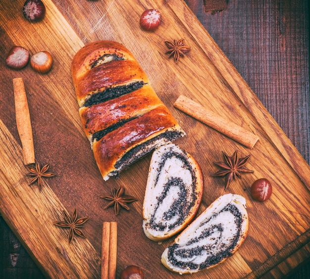 Baked roll with poppy seeds on a wooden board