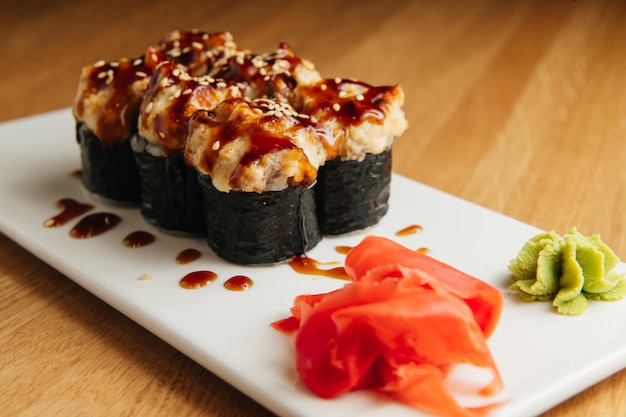 Baked roll with shrimp and masago caviar cap. Traditional sushi restaurant dish, menu item.