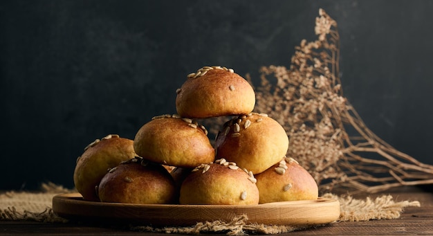 Baked round buns on a wooden table black background