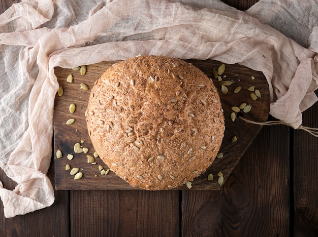 Baked round rye bread with sunflower seeds on a  textile napkin