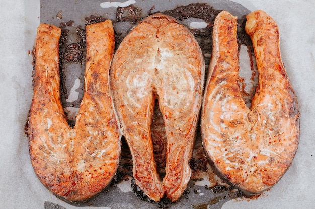 Baked salmon pieces. Juicy appetizing salmon lies on baking sheet. Red fried fish steaks