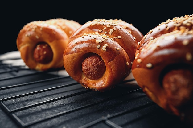 Baked sausage in dough on a dark background